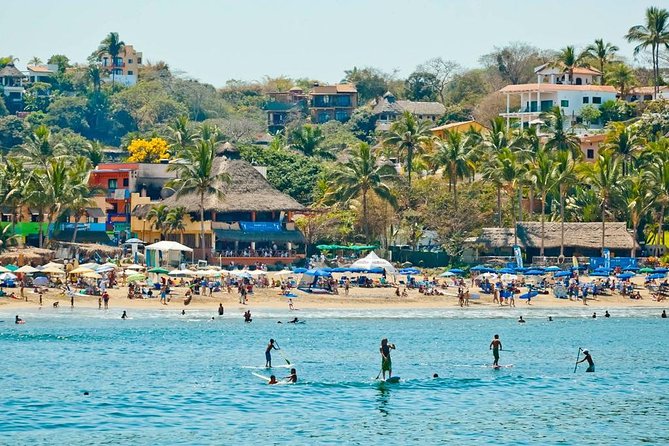 La Lancha beach in Sayulita, you can see surfers and tourists around.